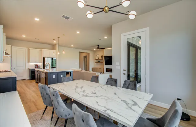 a dining room with kitchen island furniture a chandelier and kitchen view