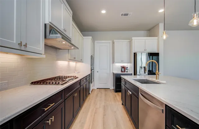 a kitchen with kitchen island stainless steel appliances a sink stove and cabinets