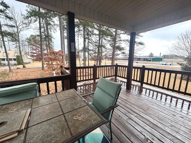 a view of a balcony with wooden floor and outdoor seating