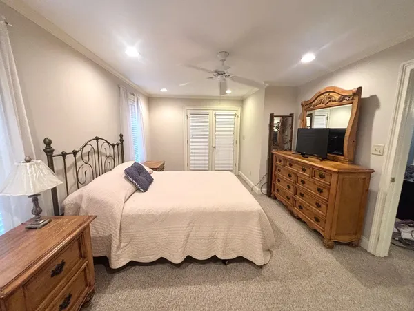 a bedroom with bed and a flat tv screen on dresser
