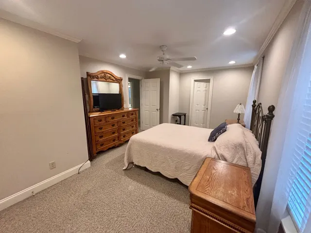 a spacious bedroom with a bed and a flat screen tv