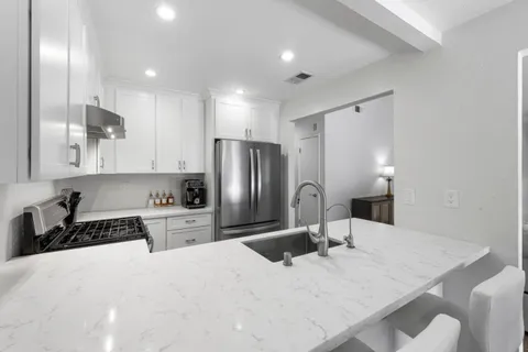 a kitchen with refrigerator cabinets and wooden floor