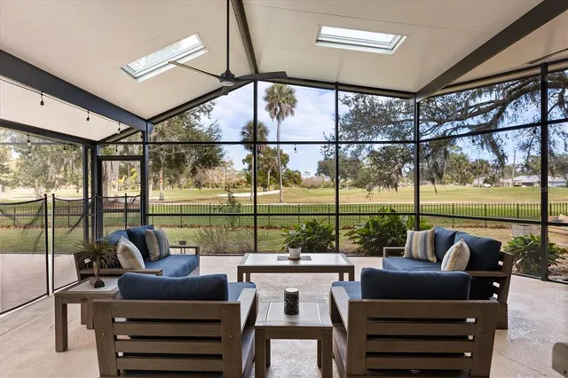 a living room with lots of furniture and a floor to ceiling window