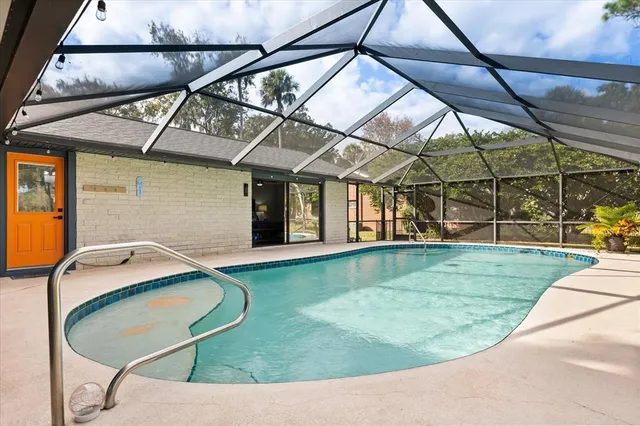 a view of a swimming pool with a patio and a yard