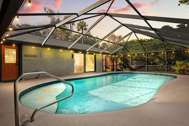 a view of a swimming pool with a patio and a yard