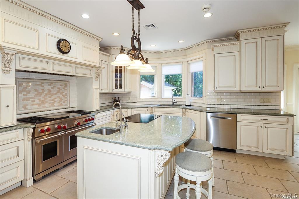 24 Steamboat Road Great Neck, NY 11024 - Photo 11 of 28 Kitchen with cream cabinetry, dark stone counters, backsplash, stainless steel appliances, and recessed lighting
