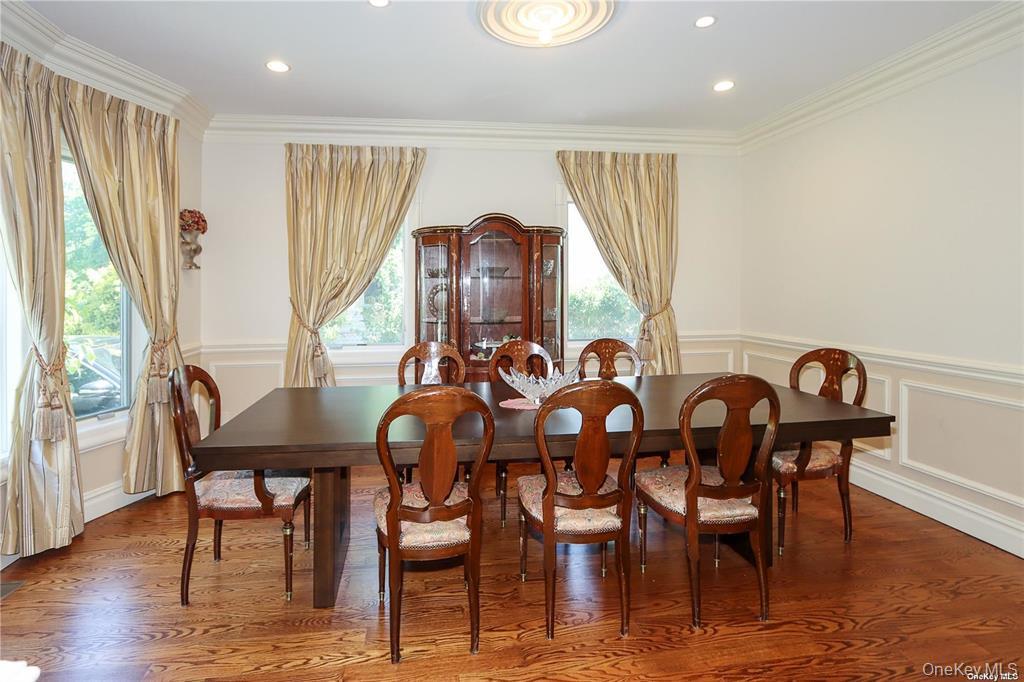 24 Steamboat Road Great Neck, NY 11024 - Photo 14 of 28 Dining room with a decorative wall, a wainscoted wall, wood finished floors, crown molding, and recessed lighting