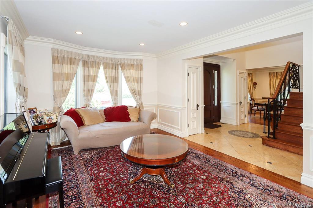 24 Steamboat Road Great Neck, NY 11024 - Photo 5 of 28 Living area featuring light wood-style flooring, ornamental molding, a wainscoted wall, recessed lighting, and a decorative wall