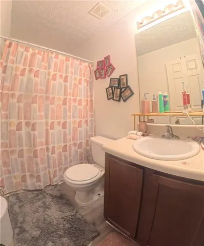 a bathroom with a toilet sink and shower curtain