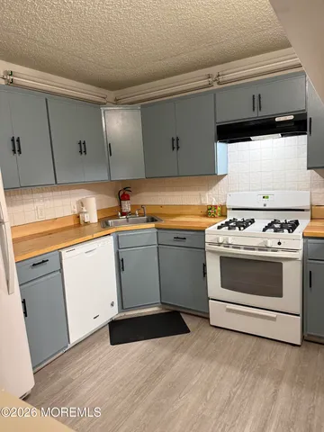a white kitchen with a stove top oven