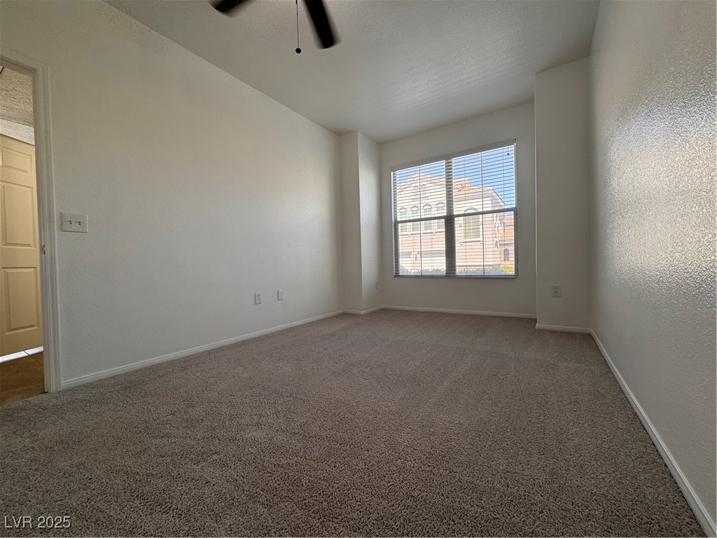 9975 Peace Way, Unit 1140 Las Vegas, NV 89147 - Photo 7 of 23 Unfurnished room featuring a ceiling fan, baseboards, and carpet