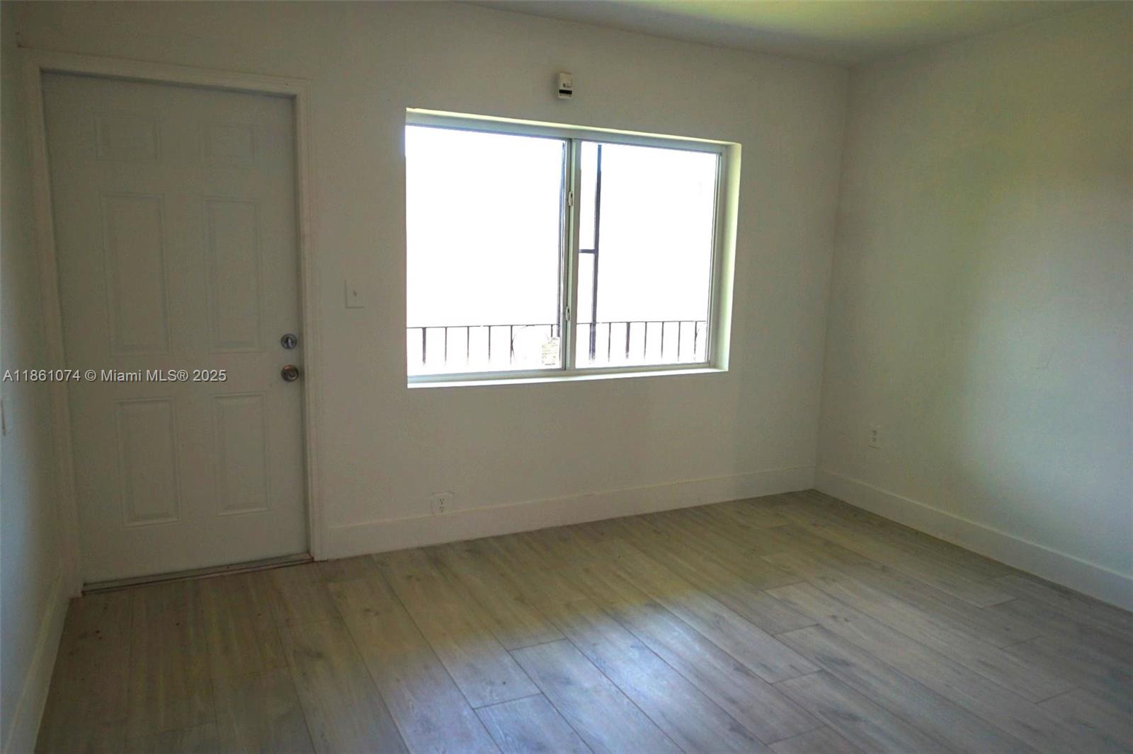 584 Northwest 65th Street, Unit 11 Miami, FL 33150 - Photo 3 of 8 an empty room with a window