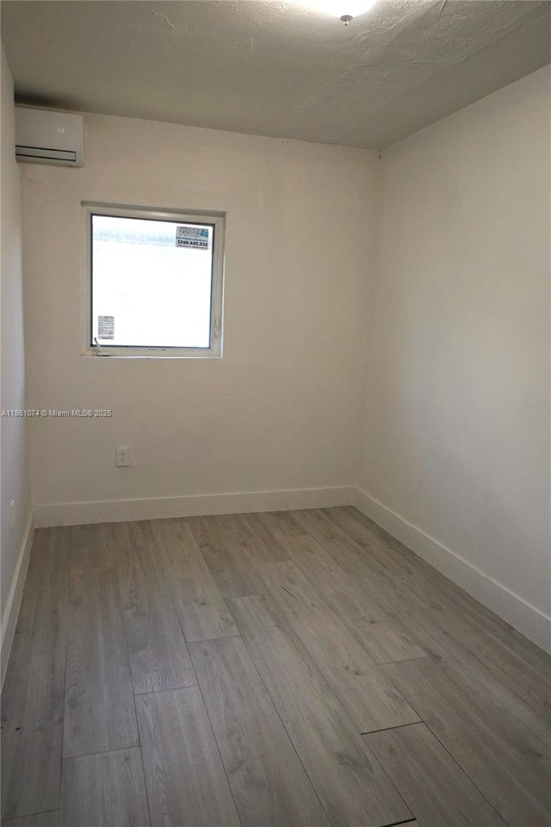 584 Northwest 65th Street, Unit 11 Miami, FL 33150 - Photo 5 of 8 a view of a small space with wooden floor and a window