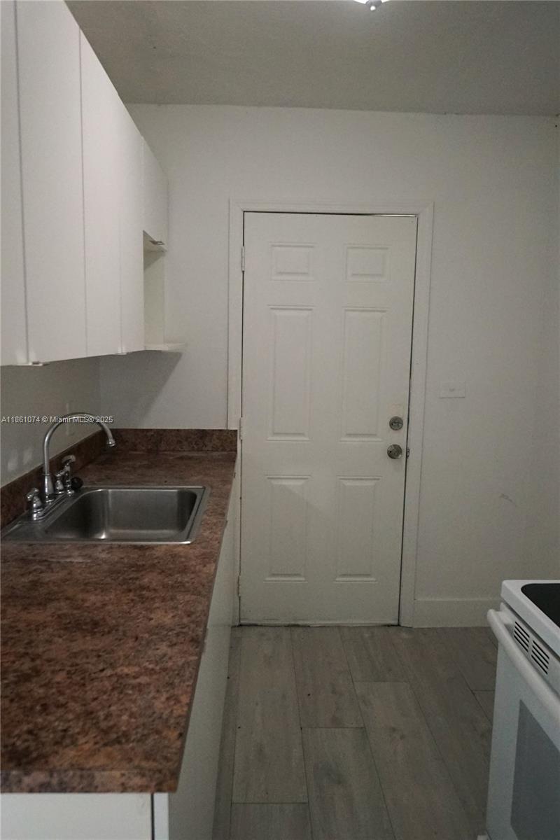 584 Northwest 65th Street, Unit 11 Miami, FL 33150 - Photo 8 of 8 a kitchen with a sink stove and cabinets