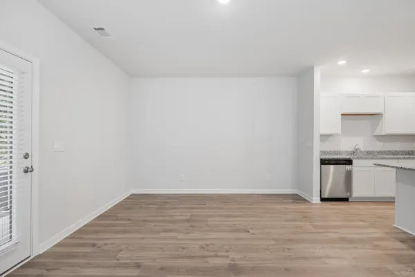 a view of a kitchen with a sink and dishwasher a refrigerator with wooden floor