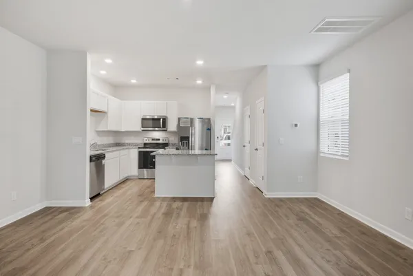 a large kitchen with cabinets wooden floor and a stainless steel appliances