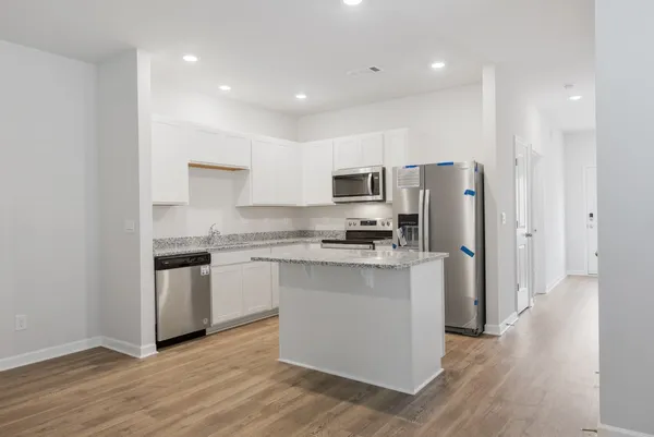 a kitchen with stainless steel appliances a refrigerator and a stove top oven