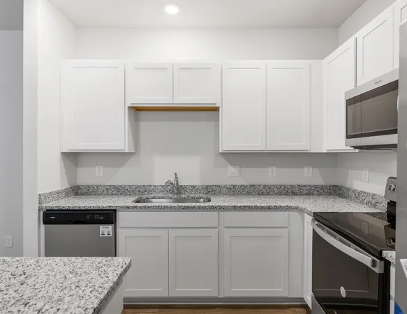 a kitchen with granite countertop cabinets stainless steel appliances and a sink