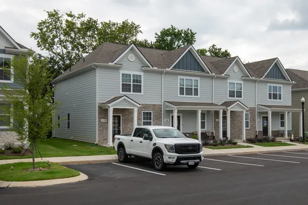 a car parked in front of a white house