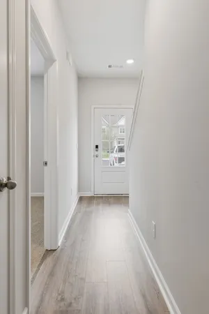 a view of a hallway with wooden floor
