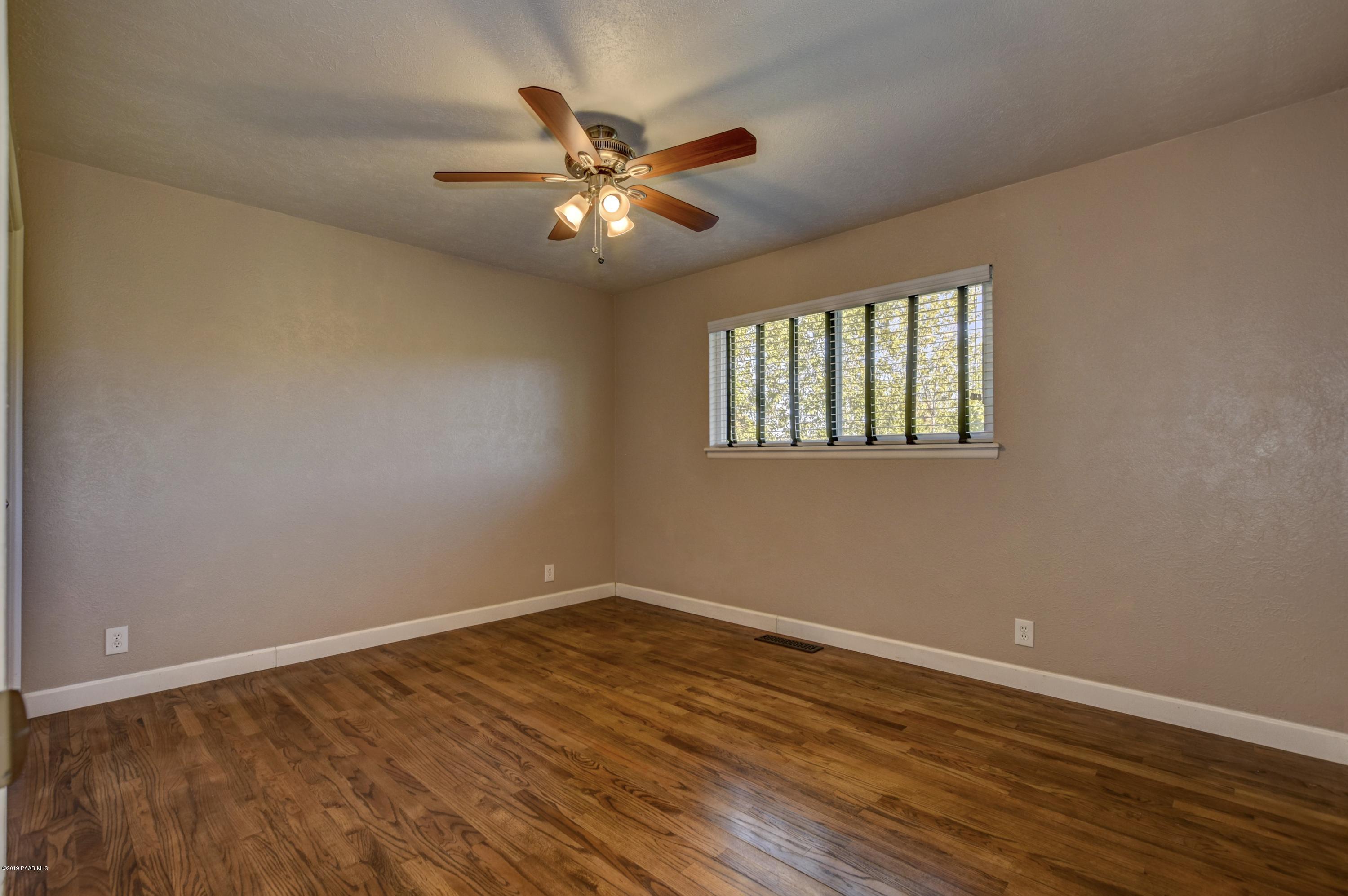 439 Canyon Springs Road Prescott, AZ 86303 - Photo 19 of 37 a view of an empty room with wooden floor and a window