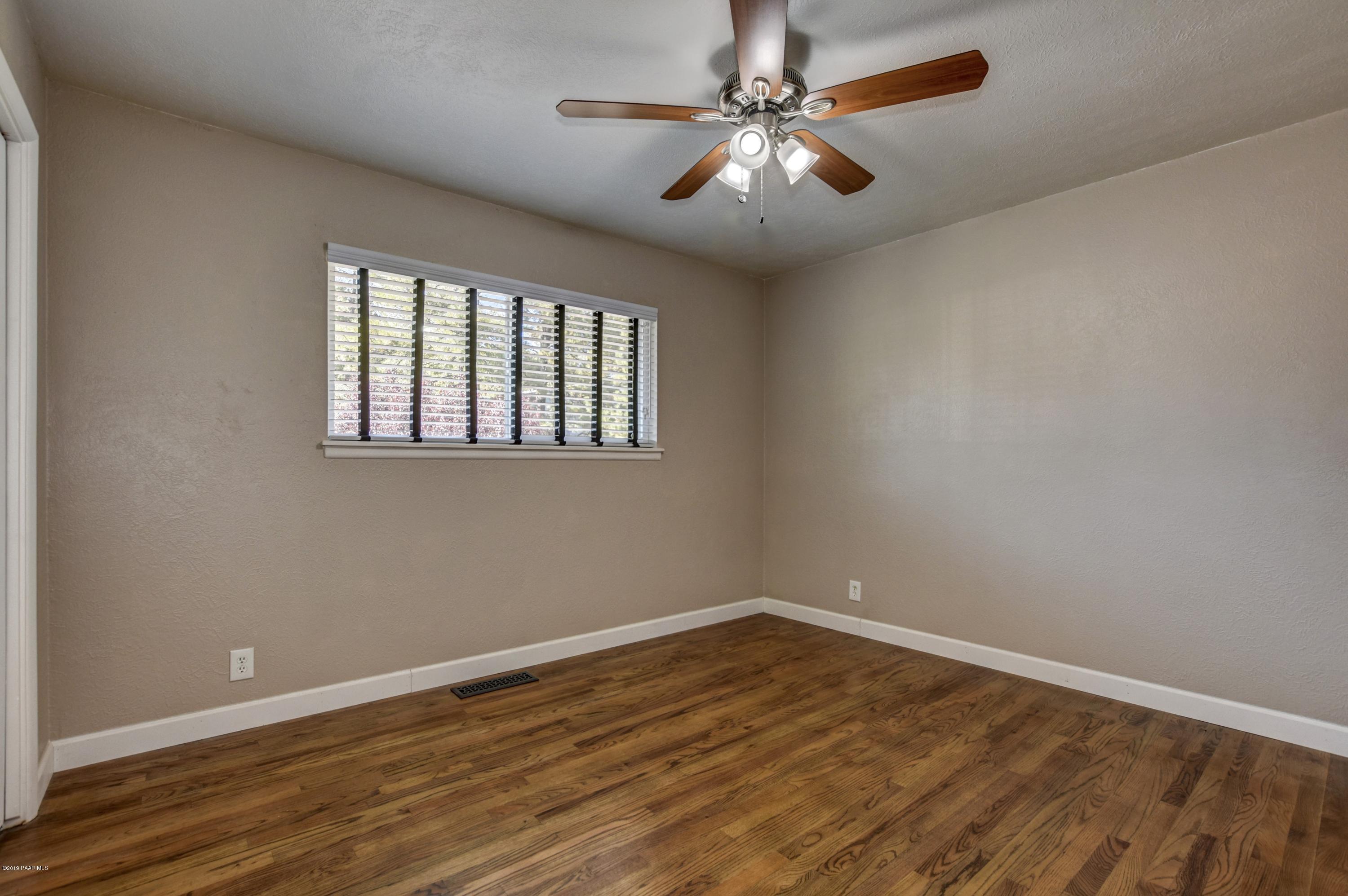 439 Canyon Springs Road Prescott, AZ 86303 - Photo 21 of 37 a view of empty room with wooden floor and fan