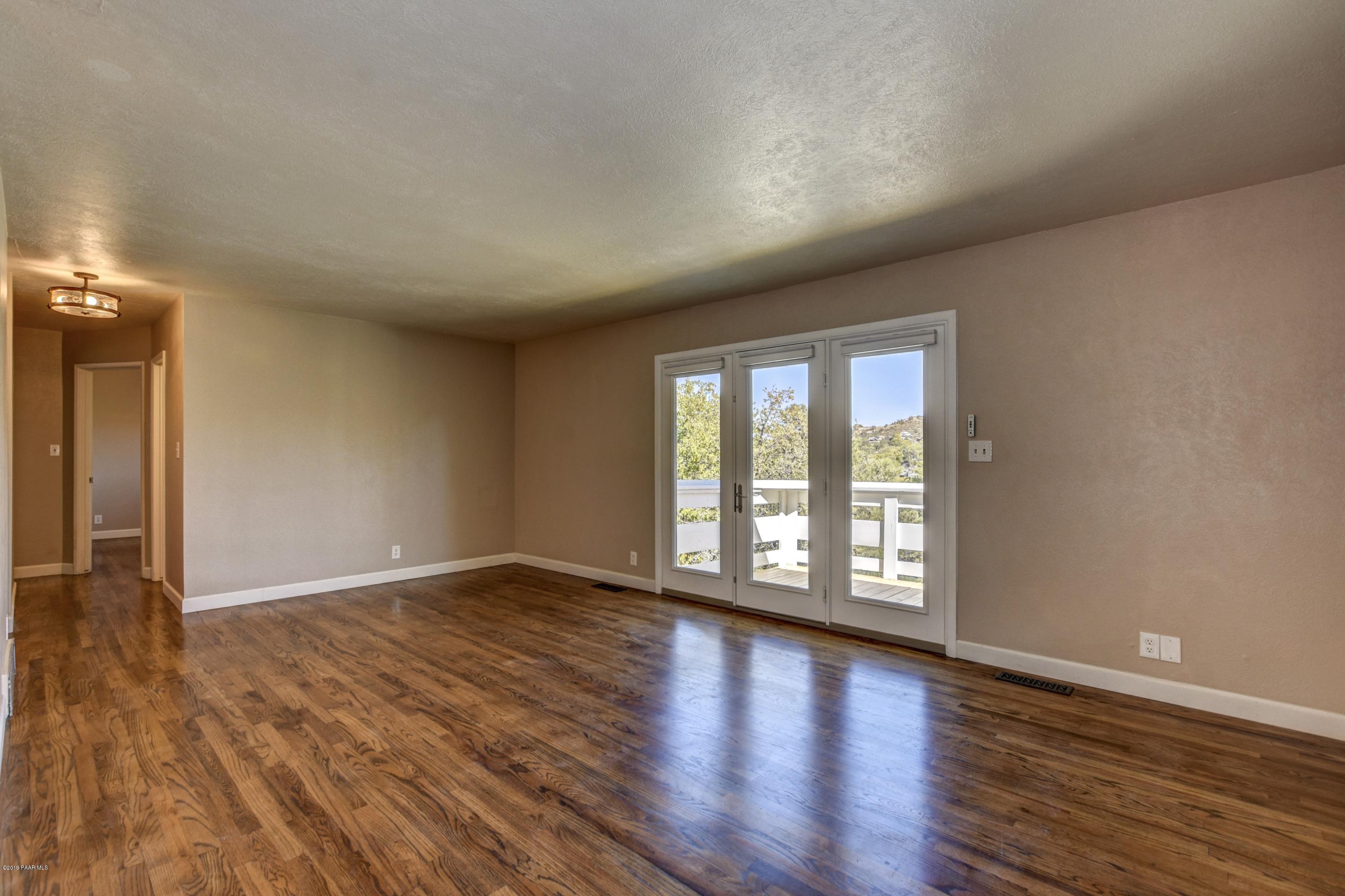 439 Canyon Springs Road Prescott, AZ 86303 - Photo 7 of 37 a view of an empty room with window and wooden floor