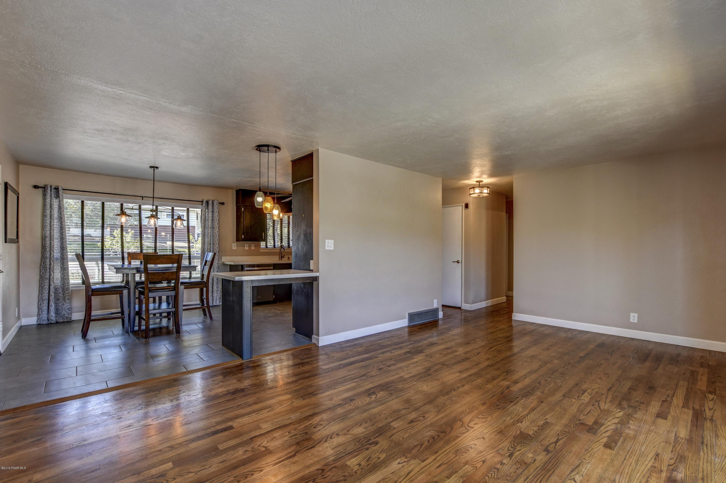 439 Canyon Springs Road Prescott, AZ 86303 - Photo 9 of 37 an empty room with wooden floor and fireplace