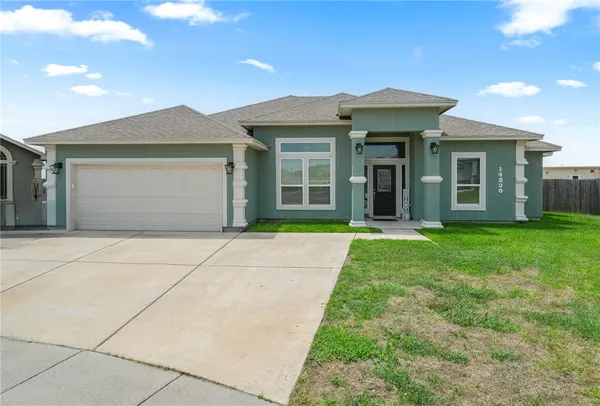 a front view of a house with a garden and yard