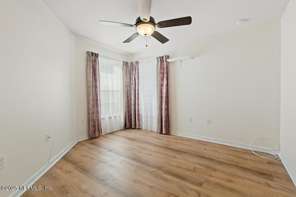 9080 Sweet Tree Trail Jacksonville, FL 32256 - Photo 25 of 44 a view of a room with a ceiling fan and a hardwood floor
