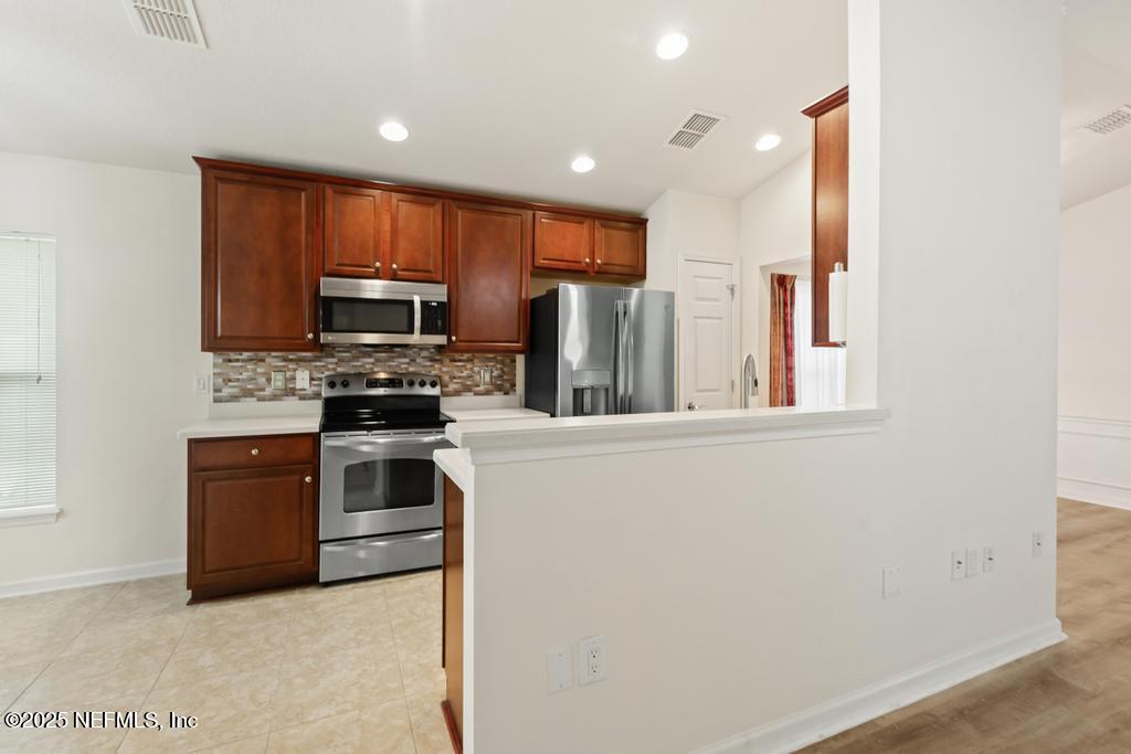 9080 Sweet Tree Trail Jacksonville, FL 32256 - Photo 6 of 44 a kitchen with stainless steel appliances a stove top oven a refrigerator and a sink