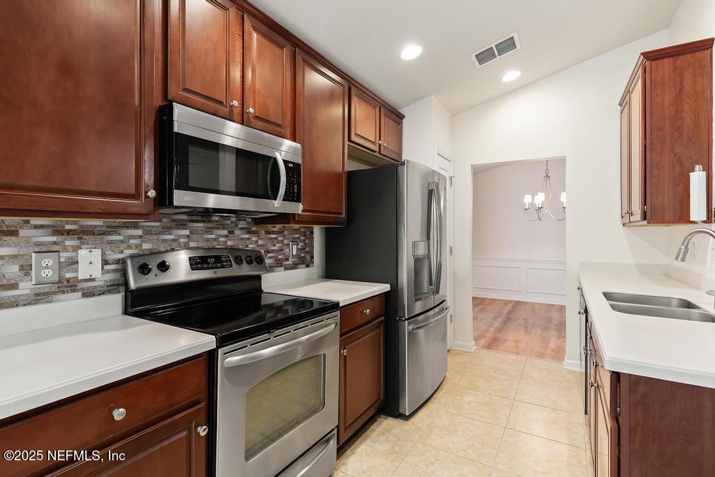 9080 Sweet Tree Trail Jacksonville, FL 32256 - Photo 8 of 44 a kitchen with stainless steel appliances a stove a sink a microwave a refrigerator and cabinets