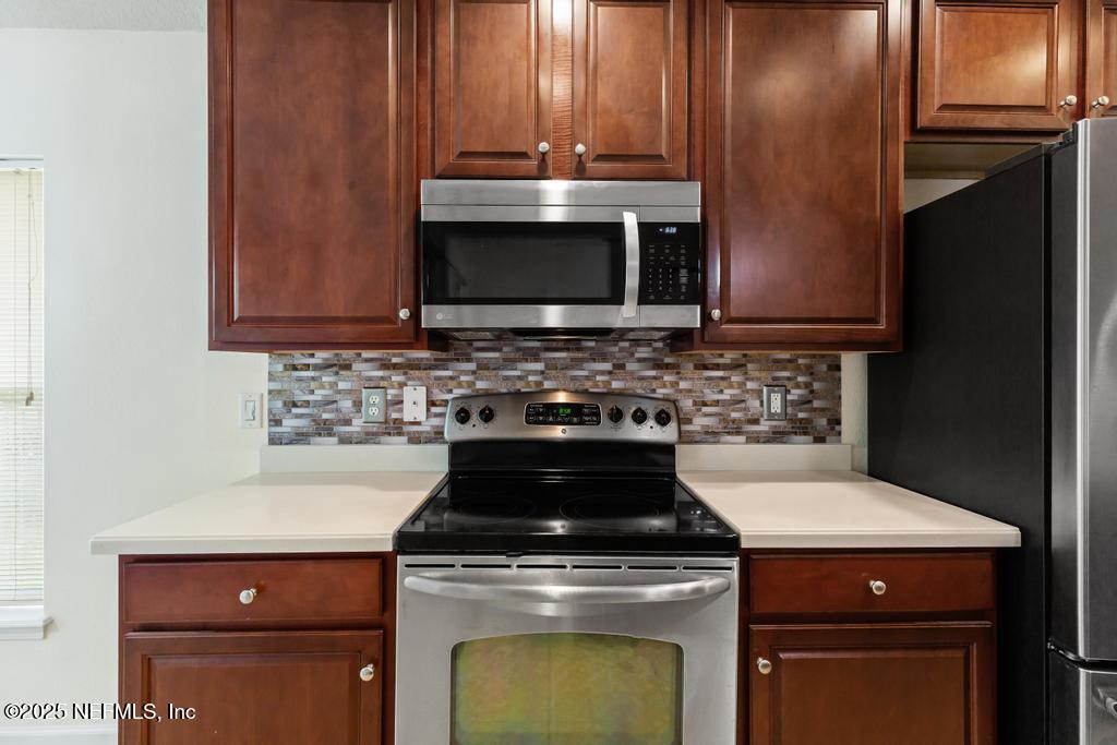 9080 Sweet Tree Trail Jacksonville, FL 32256 - Photo 10 of 44 a kitchen with granite countertop a stove top oven microwave and cabinets