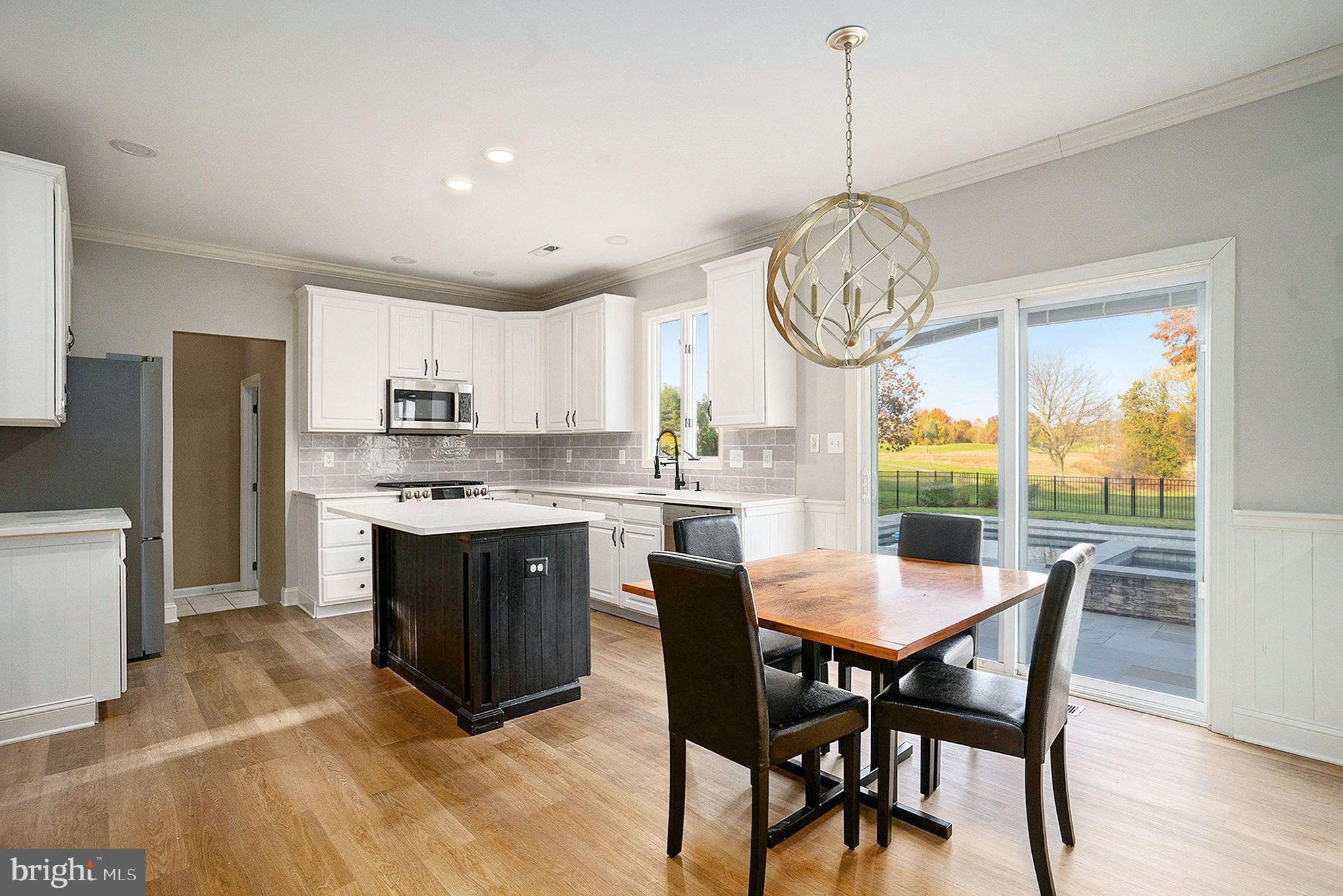 127 Spyglass Drive Blue Bell, PA 19422 - Photo 11 of 74 a kitchen with stainless steel appliances granite countertop a stove a sink dishwasher a dining table and chairs with wooden floor