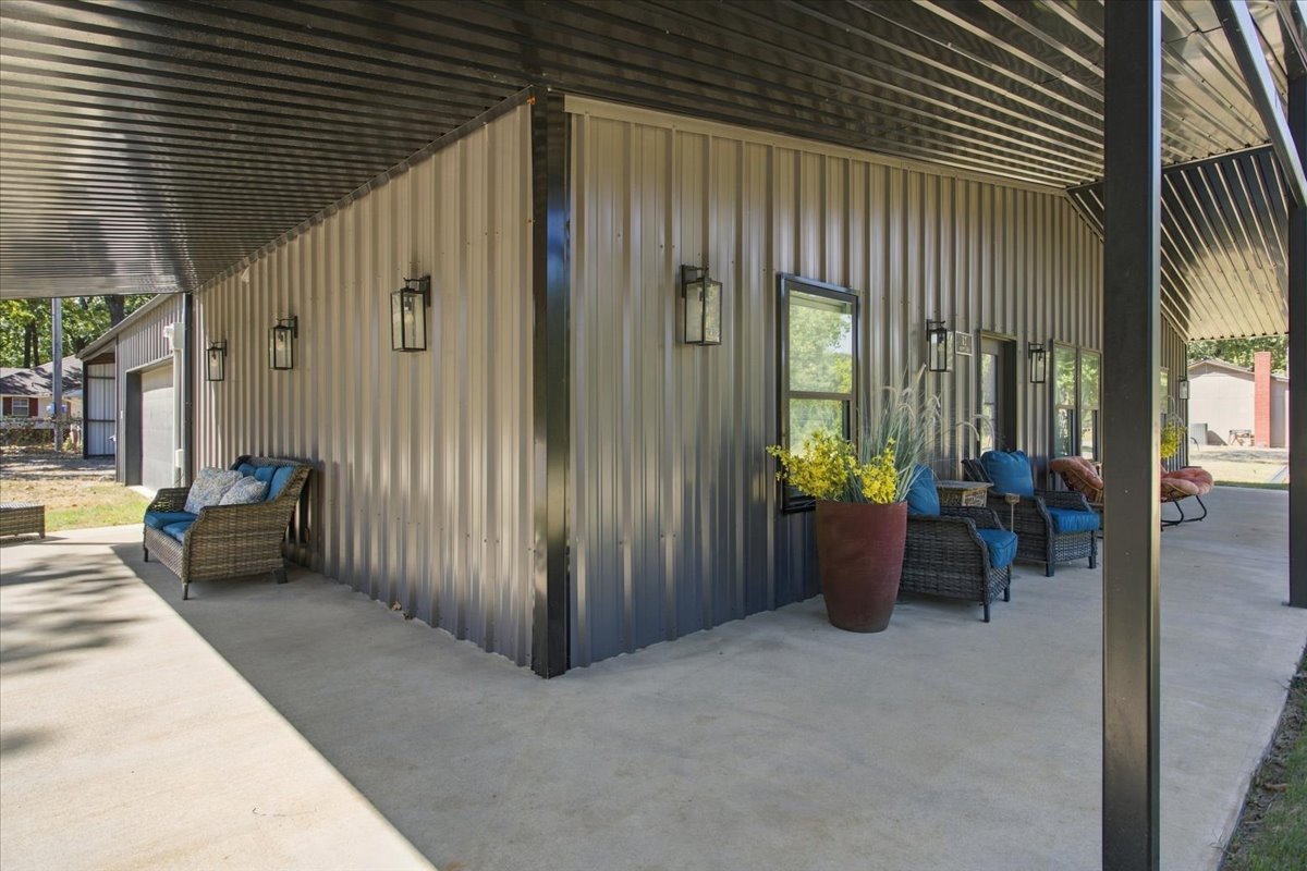 12 Hoot Loop Cartwright, OK 74731 - Photo 4 of 35 Expansive covered concrete patio with corrugated metal ceiling and three wall-mounted exterior light fixtures