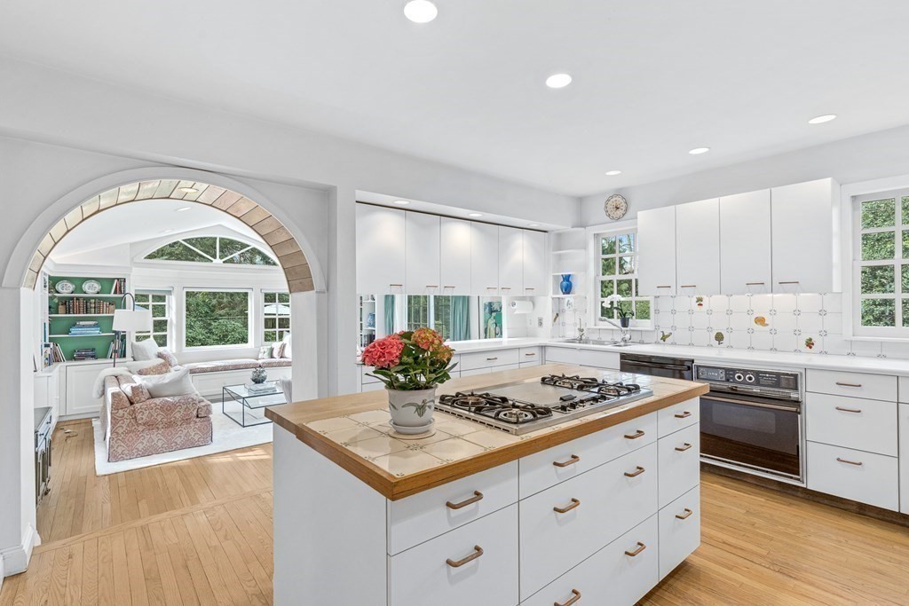 218 Middlesex Road Brookline, MA 02467 - Photo 11 of 30 a kitchen with stainless steel appliances granite countertop a stove a sink dishwasher and white cabinets with wooden floor