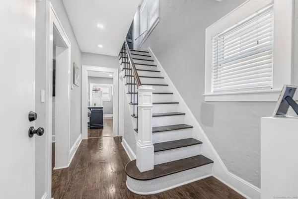 a view of entryway and hall with wooden floor
