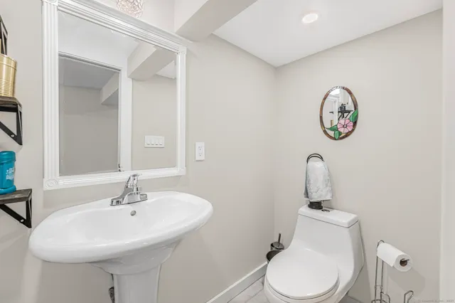 a bathroom with a toilet a sink and a mirror