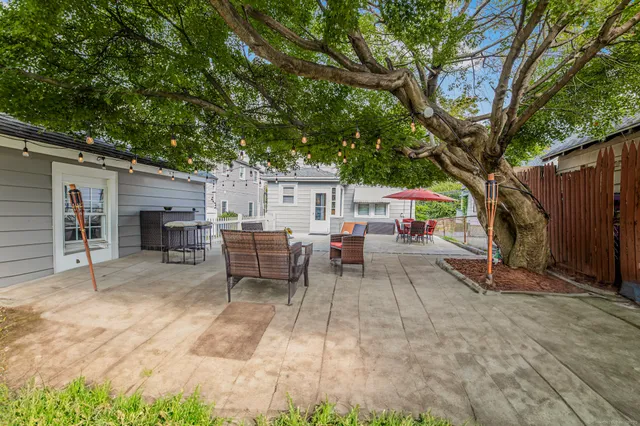 a view of a patio with table and chairs and a large tree