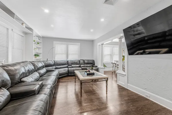 a living room with furniture and a wooden floor