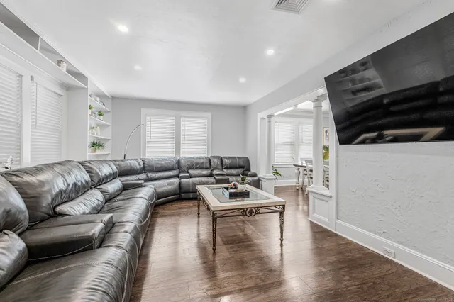 a living room with furniture and a wooden floor