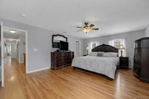 a spacious bedroom with a bed and a flat screen tv