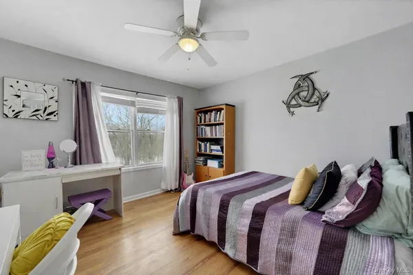 a bedroom with a bed and a wooden floor