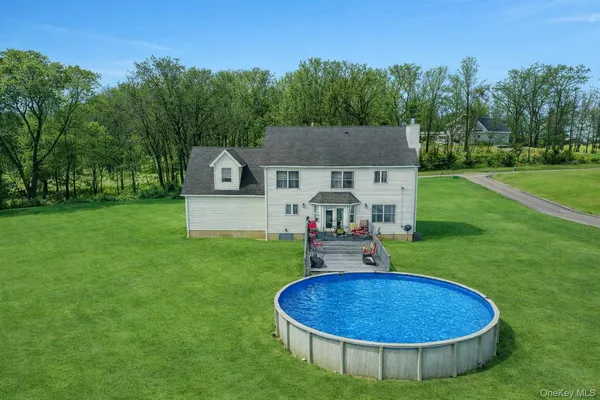 a view of a swimming pool with a garden and fire pit