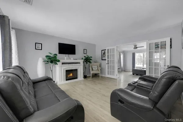 a living room with furniture a flat screen tv and a fireplace