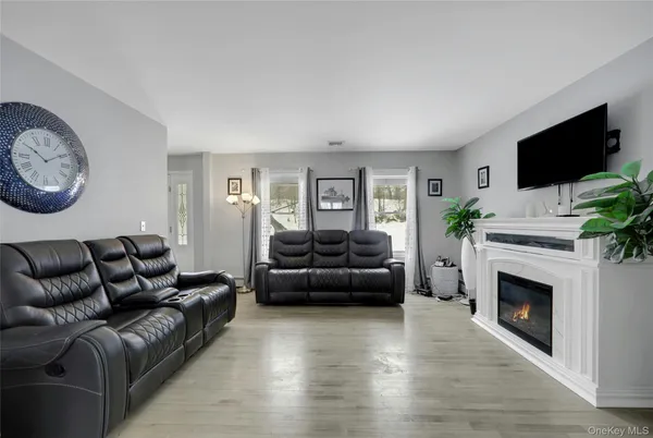 a living room with furniture a flat screen tv and a fireplace