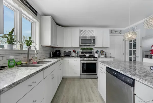 a kitchen with stainless steel appliances granite countertop a sink stove and cabinets