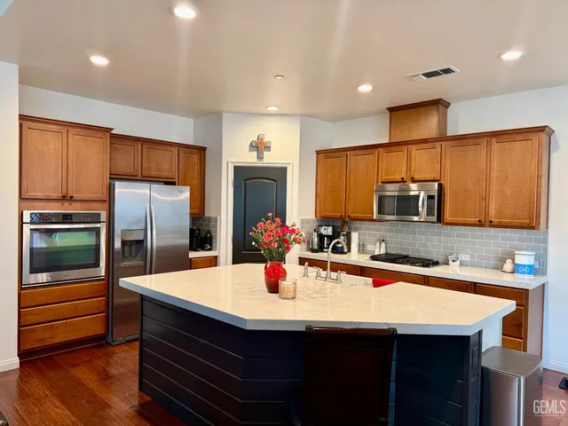 a kitchen with stainless steel appliances kitchen island granite countertop a sink and cabinets