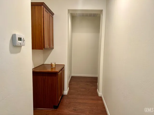 a hallway with front door wooden floor and cabinet
