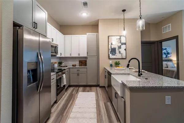 a kitchen with stainless steel appliances granite countertop a sink refrigerator and microwave